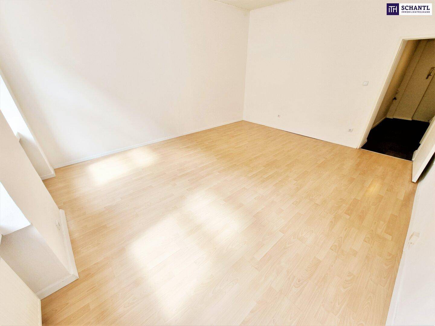 Leeres Zimmer mit hellem Holzfußboden und schrägen Wänden, bietet vielseitige Gestaltungsmöglichkeiten.