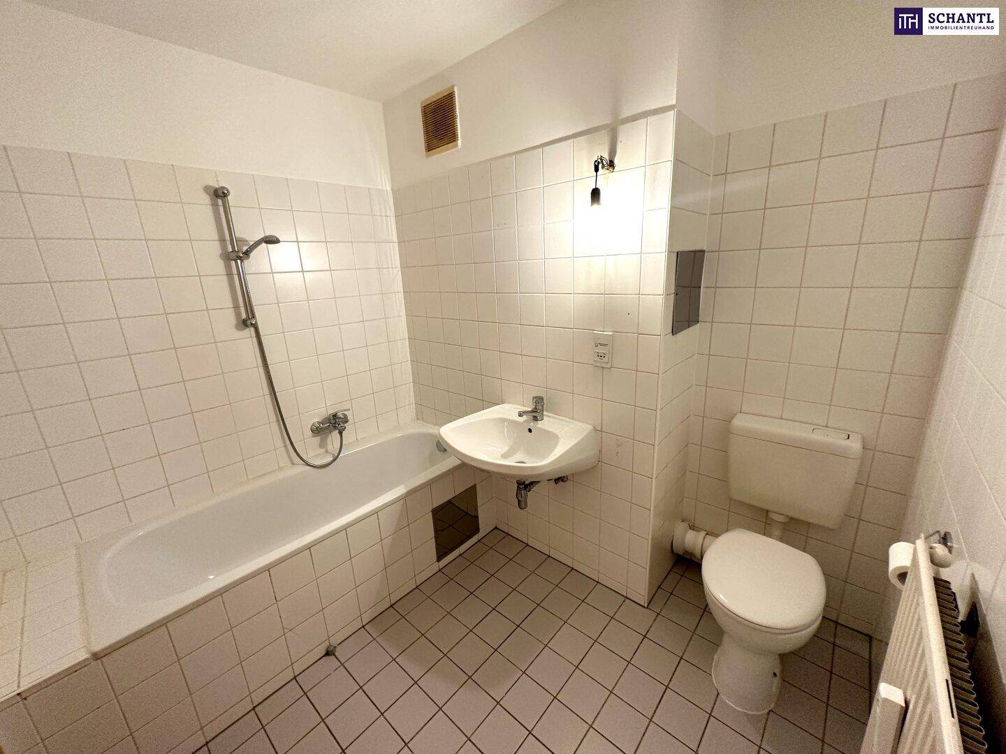 Funktionales Badezimmer mit Badewanne, WC, Waschbecken und weißen Wandfliesen.