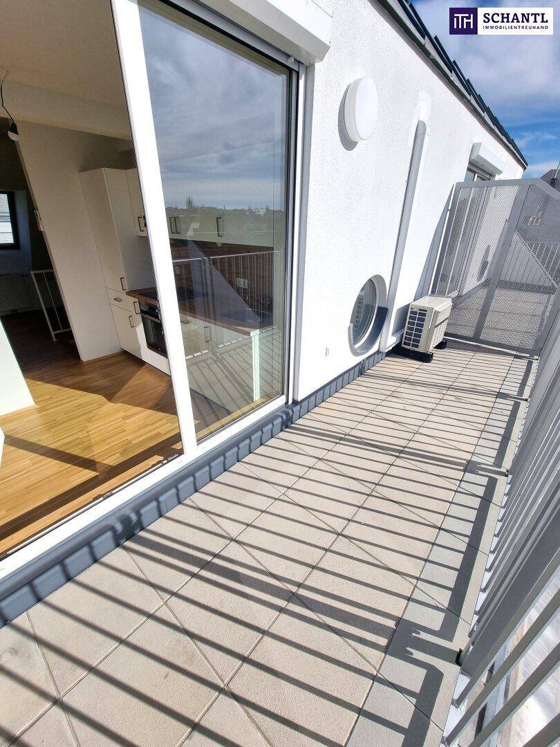 Sonnige Dachterrasse mit Fliesenboden, Klimaanlage und weitem Blick über die Stadt.