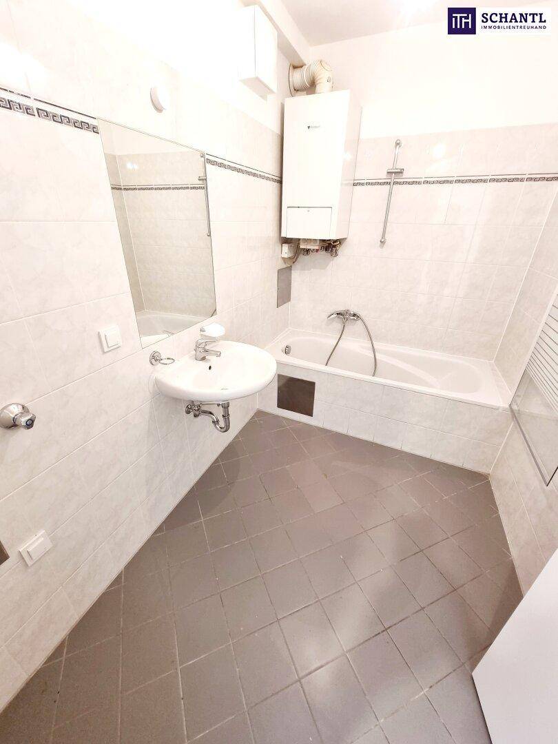 Helles Badezimmer mit Badewanne, Waschbecken und weißen Fliesen.