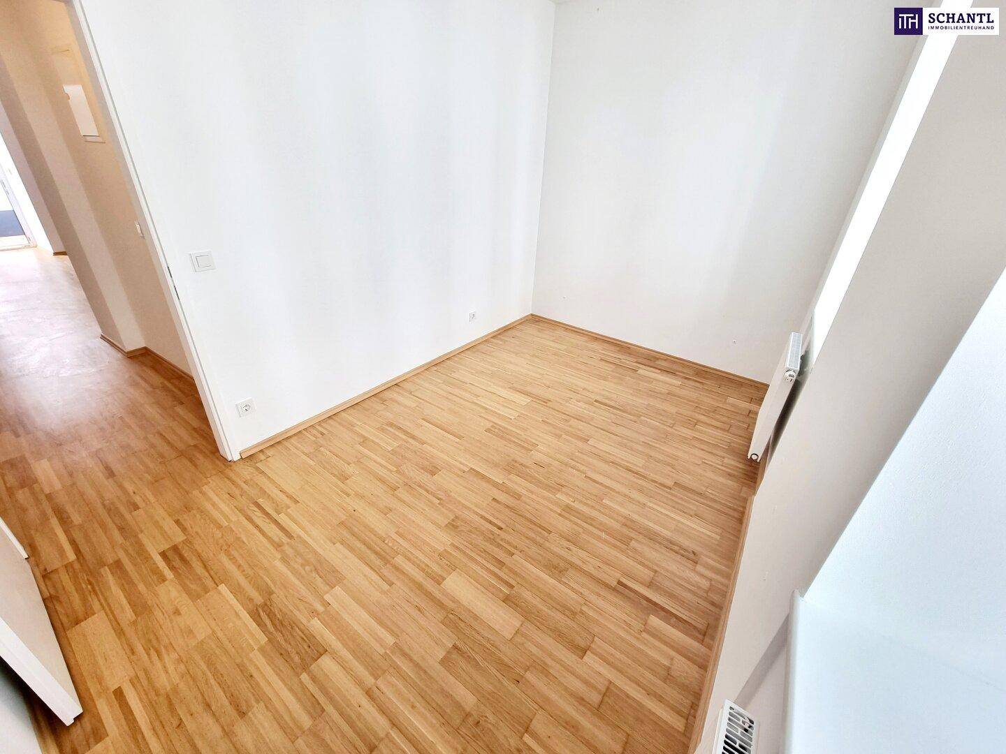 Helles Zimmer mit Parkettboden und weißen Wänden, ideal als Schlaf- oder Arbeitszimmer.