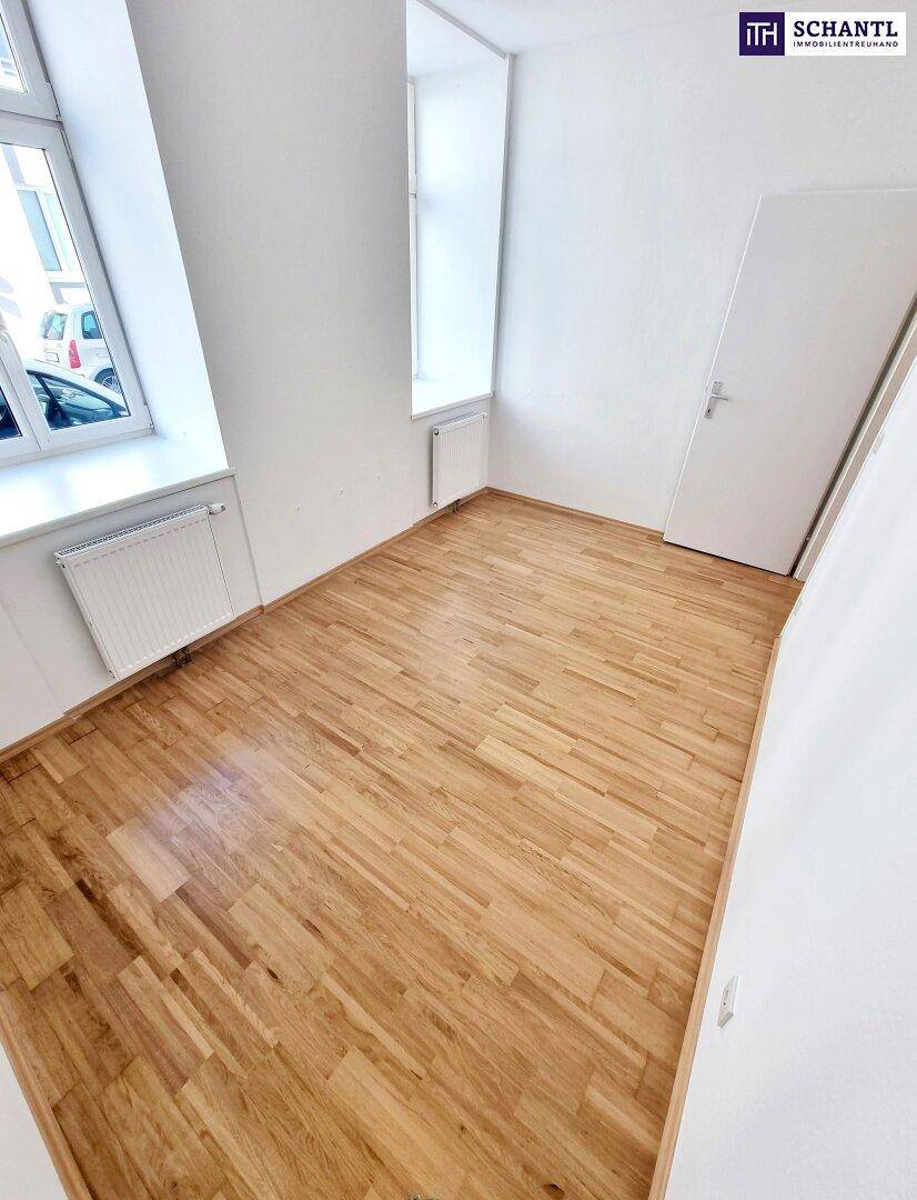 Helles Zimmer mit Parkettboden und großem Fenster, ideal für individuelle Nutzung.