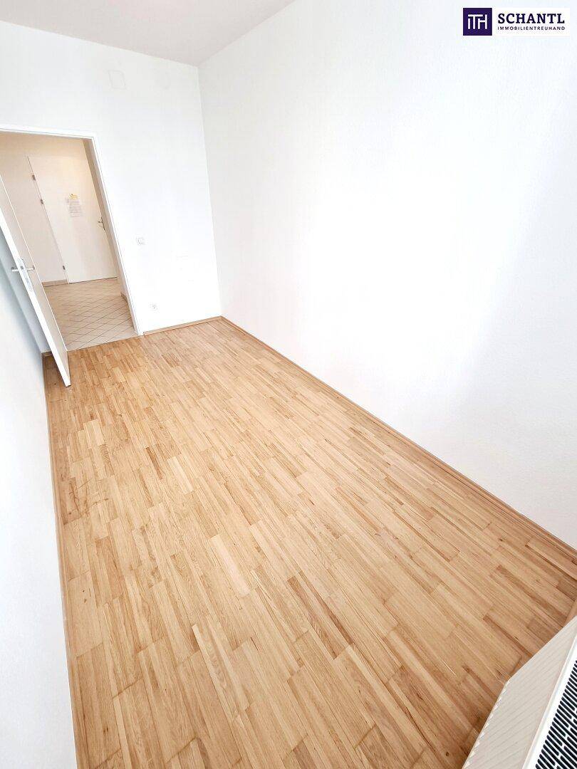 Kleineres Zimmer mit Parkettboden und weiß gestrichenen Wänden.