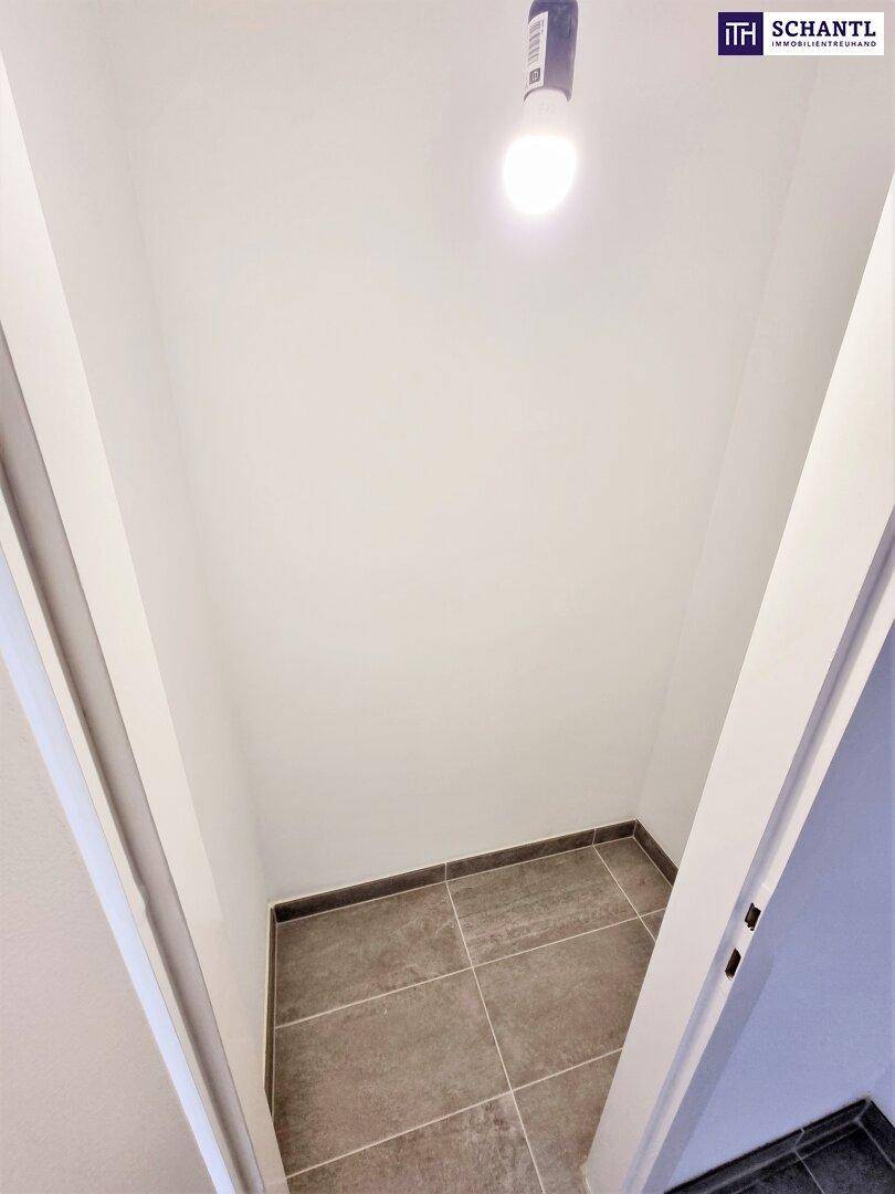 Kleiner Abstellraum mit grauen Fliesen, ideal für zusätzlichen Stauraum.