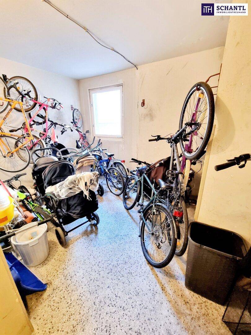 Gemeinschaftlicher Fahrradraum mit mehreren Fahrrädern und Kinderwagen, praktisch für Bewohner.