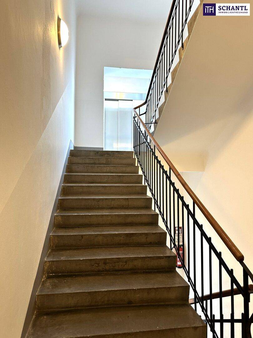 Schlichtes Treppenhaus mit Betonstufen und einem Metallgeländer, das zu den oberen Etagen führt.