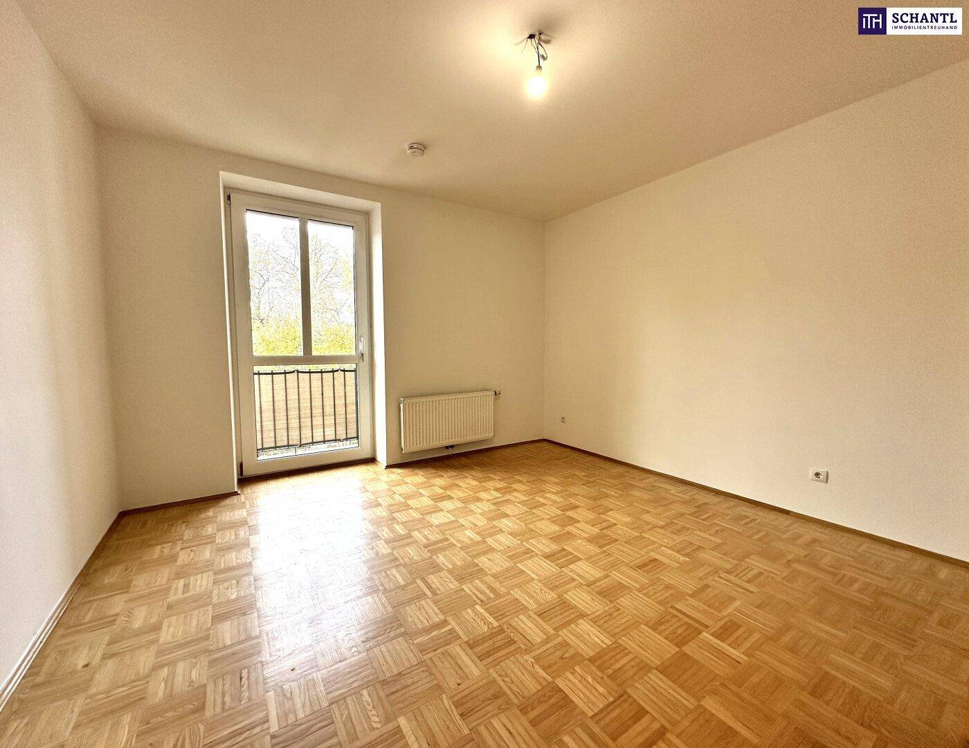 Schlafzimmer mit Parkettboden und Zugang zu einem französischen Balkon, ideal für frische Luft.
