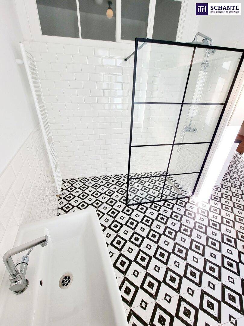 Modernes Badezimmer mit begehbarer Dusche, Heizkörper und schwarz-weiß gemusterten Bodenfliesen.