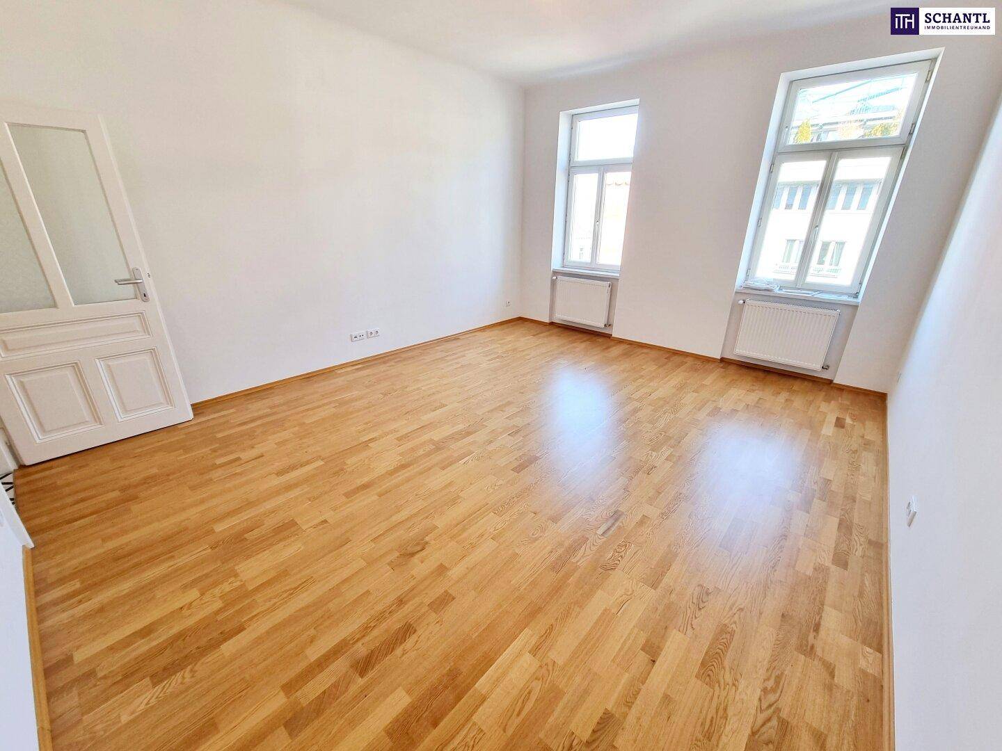 Freundlicher Raum mit Parkettboden und zwei Fenstern, ideal für individuelle Einrichtungsideen.