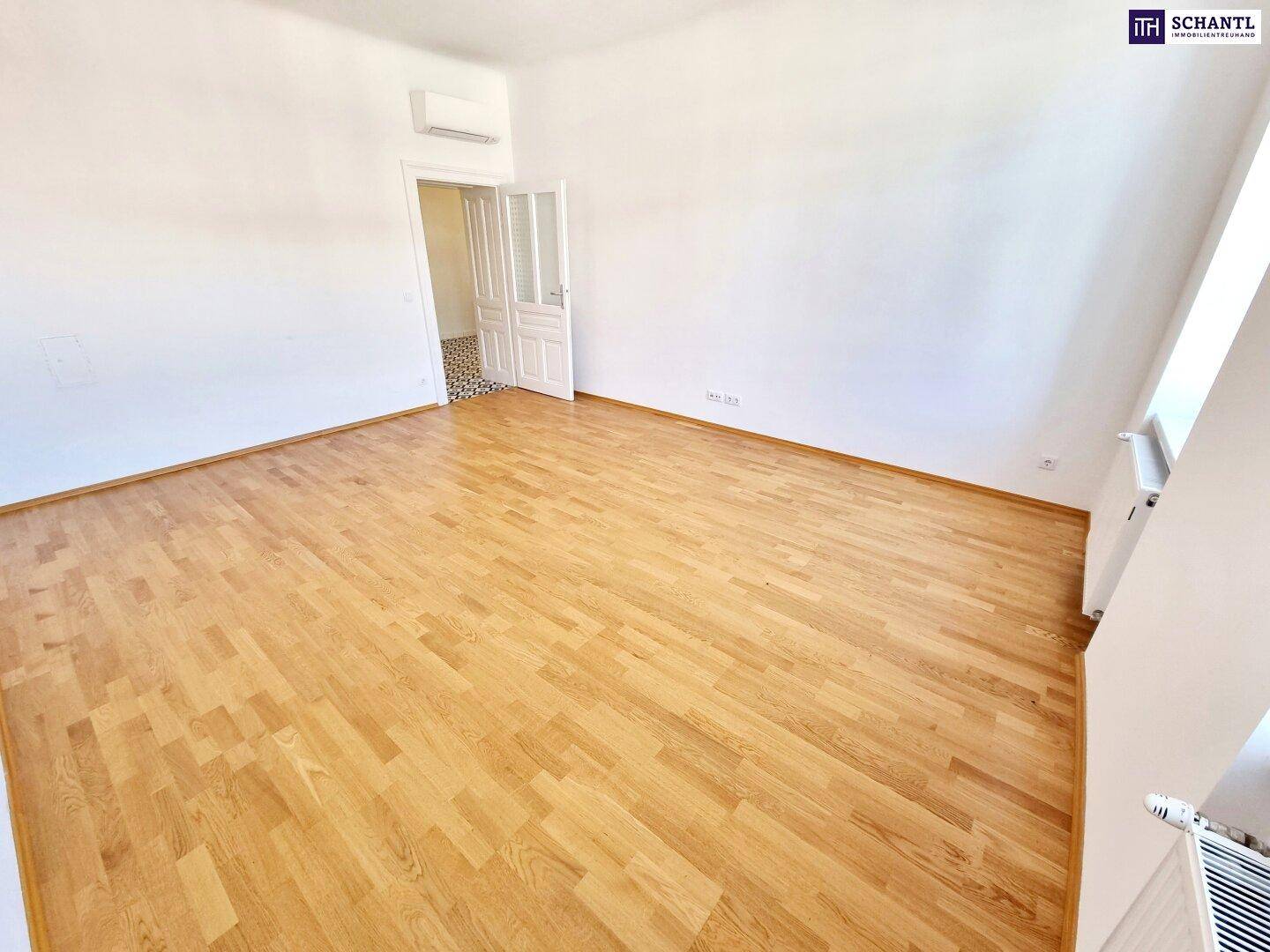 Geräumiger, heller Raum mit Parkettboden und Klimaanlage, ideal für vielfältige Nutzungsmöglichkeiten.