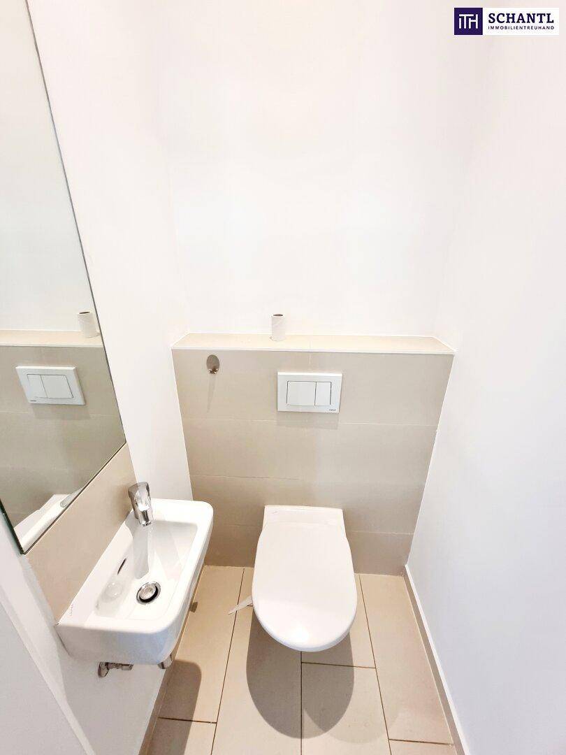 Kompaktes Gäste-WC mit wandmontierter Toilette und kleinem Waschbecken, sauber und funktional.