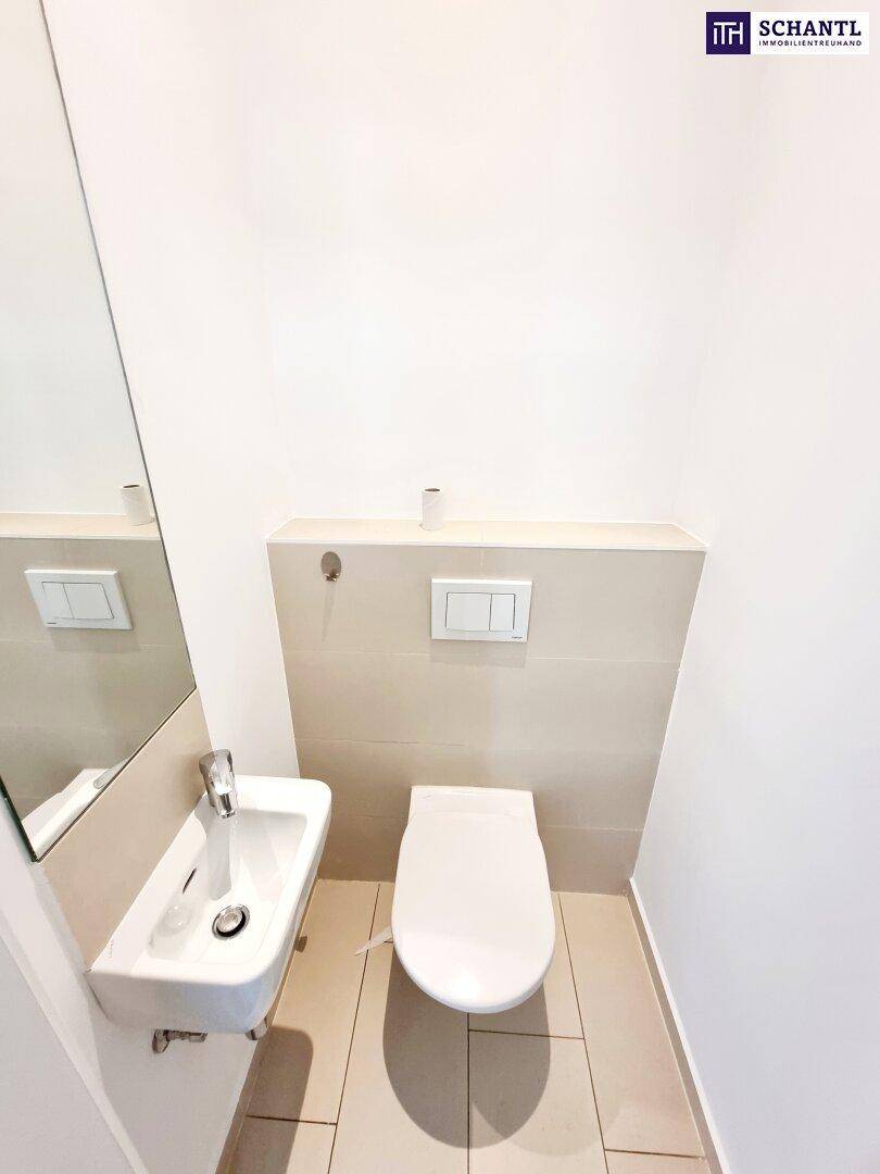 Modernes Gäste-WC mit wandhängender Toilette und kleinem Waschbecken.