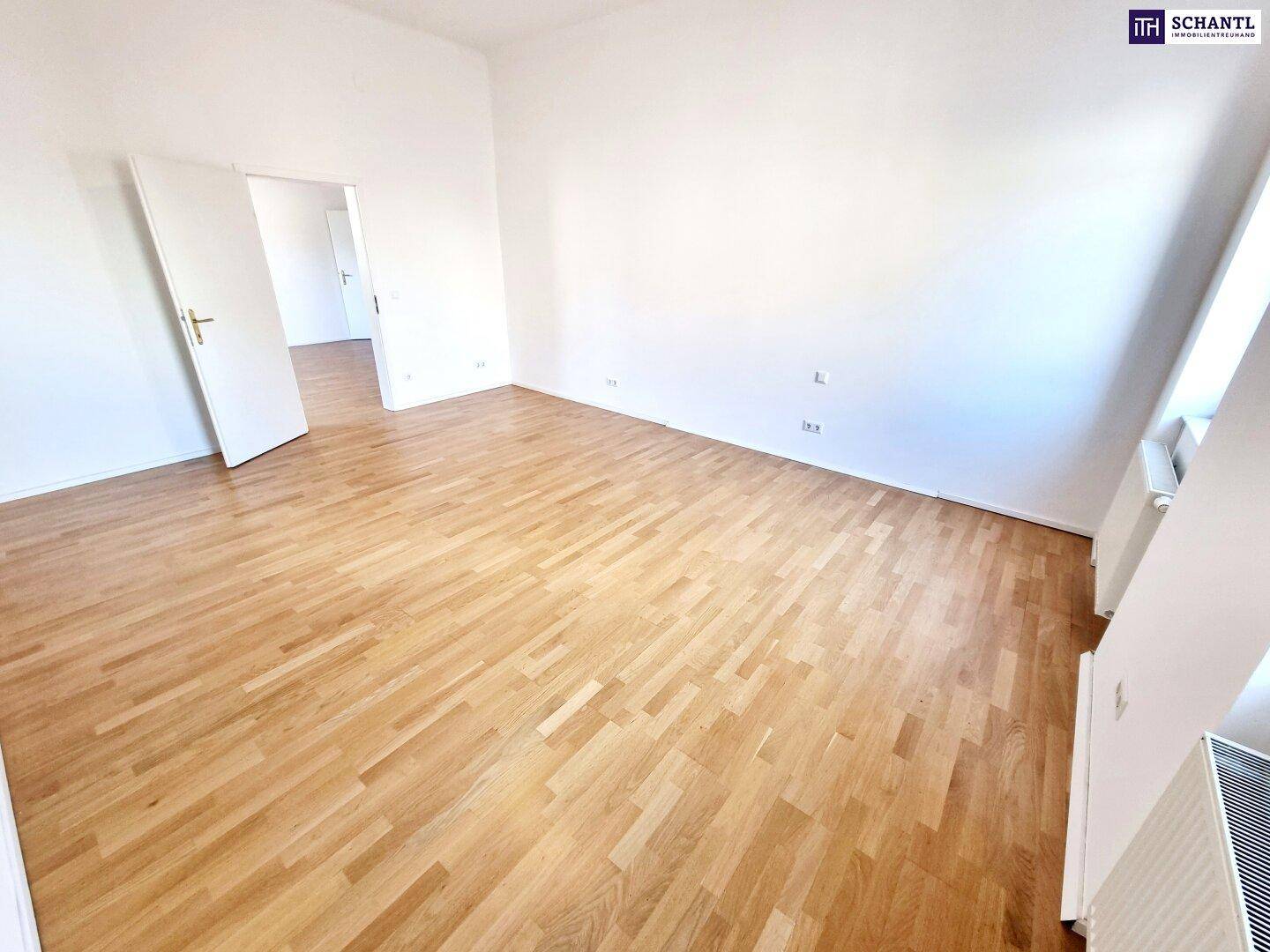 Heller Raum mit Parkettboden und Zugang zu weiteren Zimmern, ideal für flexible Nutzung.