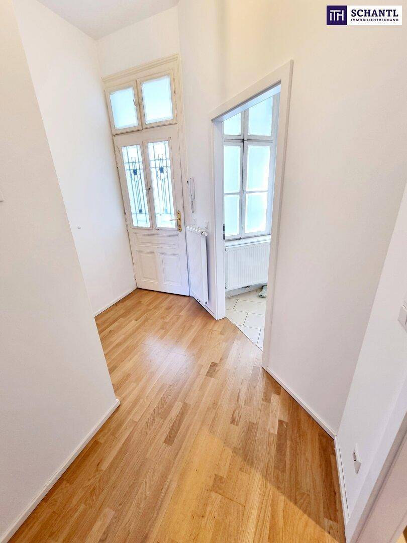Heller Eingangsbereich mit Holzparkettboden und Türen zu weiteren Räumen.