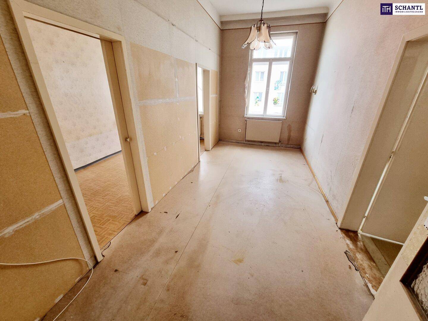 Langer Flur in Renovierungsphase mit glatten Wänden und Blick auf ein Fenster.