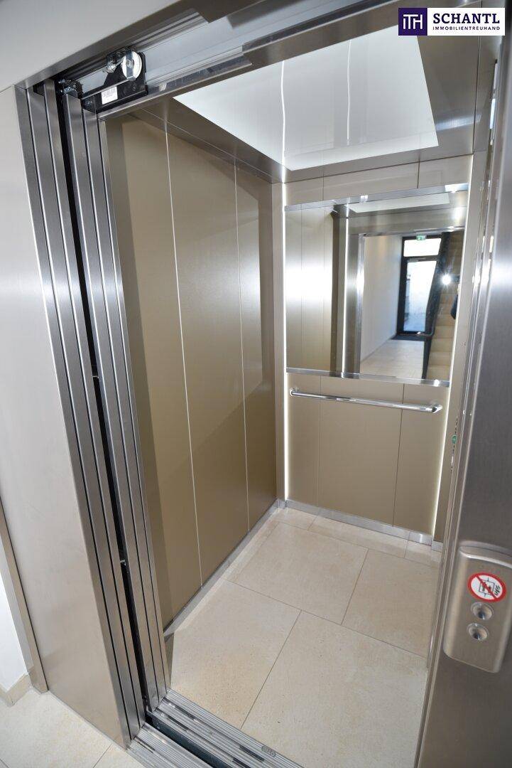 Moderner Aufzug mit Edelstahloberflächen und Spiegelflächen im Inneren.