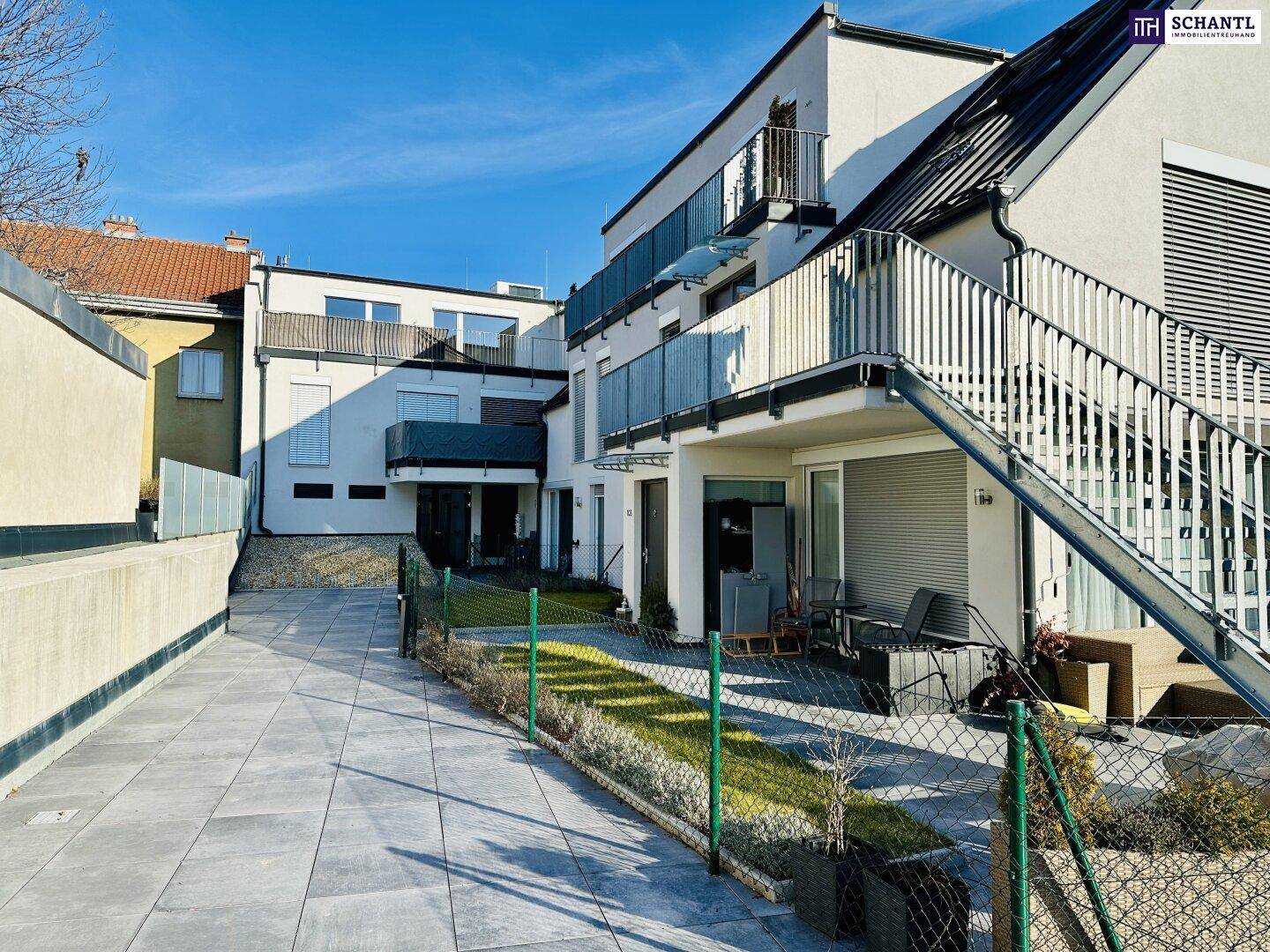 Außenbereich mit Terrasse, Sitzgelegenheiten und Blick auf die moderne Architektur.