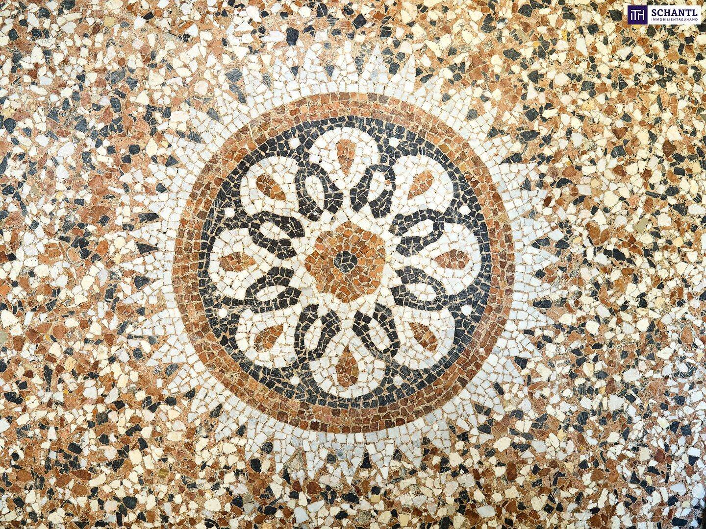 Detailaufnahme eines kunstvollen Mosaikbodens mit geometrischen und floralen Mustern.