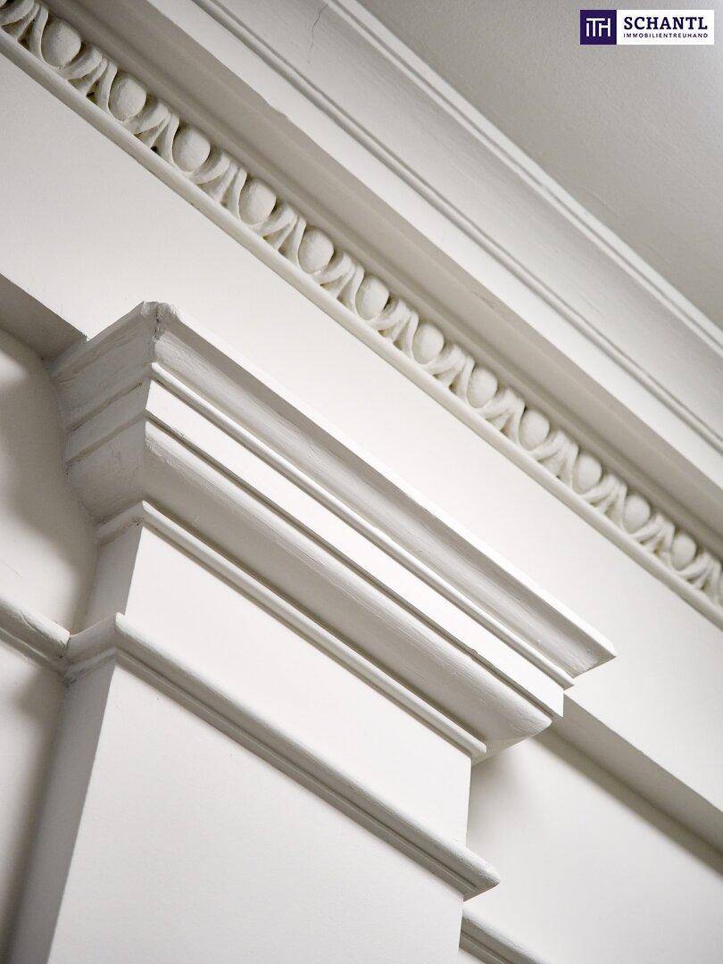 Detailaufnahme von aufwendigen Stuckverzierungen an Decke und Wand in einem historischen Gebäude.