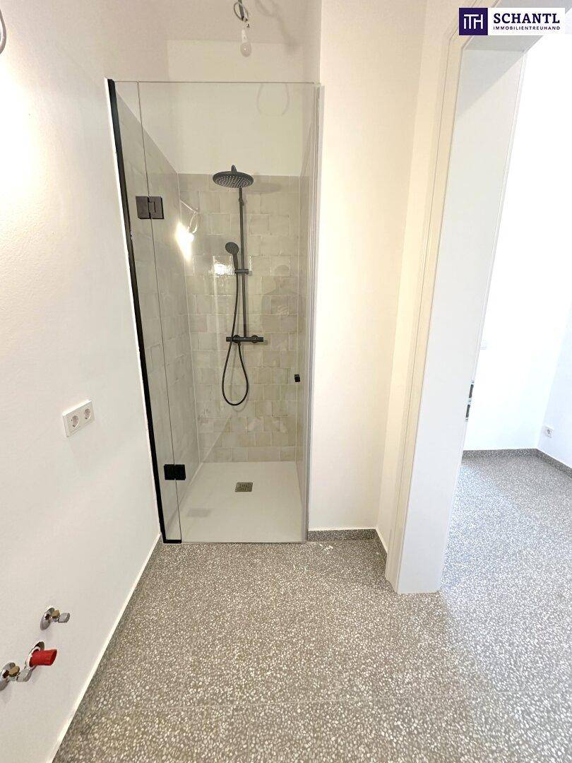 Modernes Badezimmer mit ebenerdiger Dusche und Terrazzoboden, bereit für die Endausstattung.