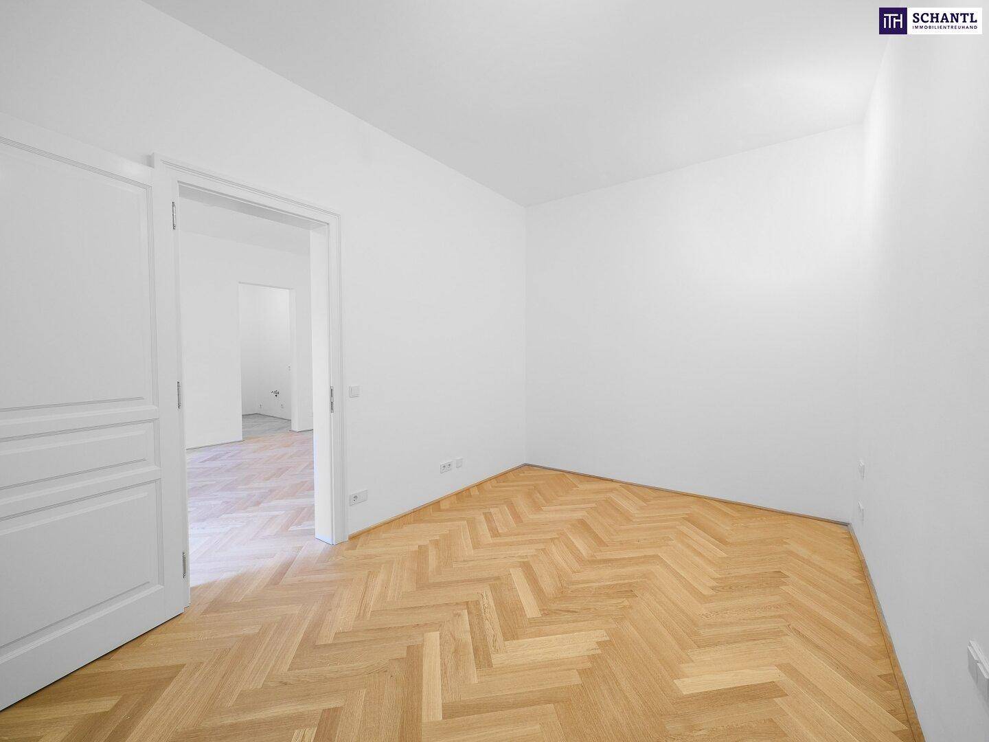 Leeres Zimmer mit Fischgrätparkett und weiß gestrichenen Wänden, ideal als Schlafzimmer.