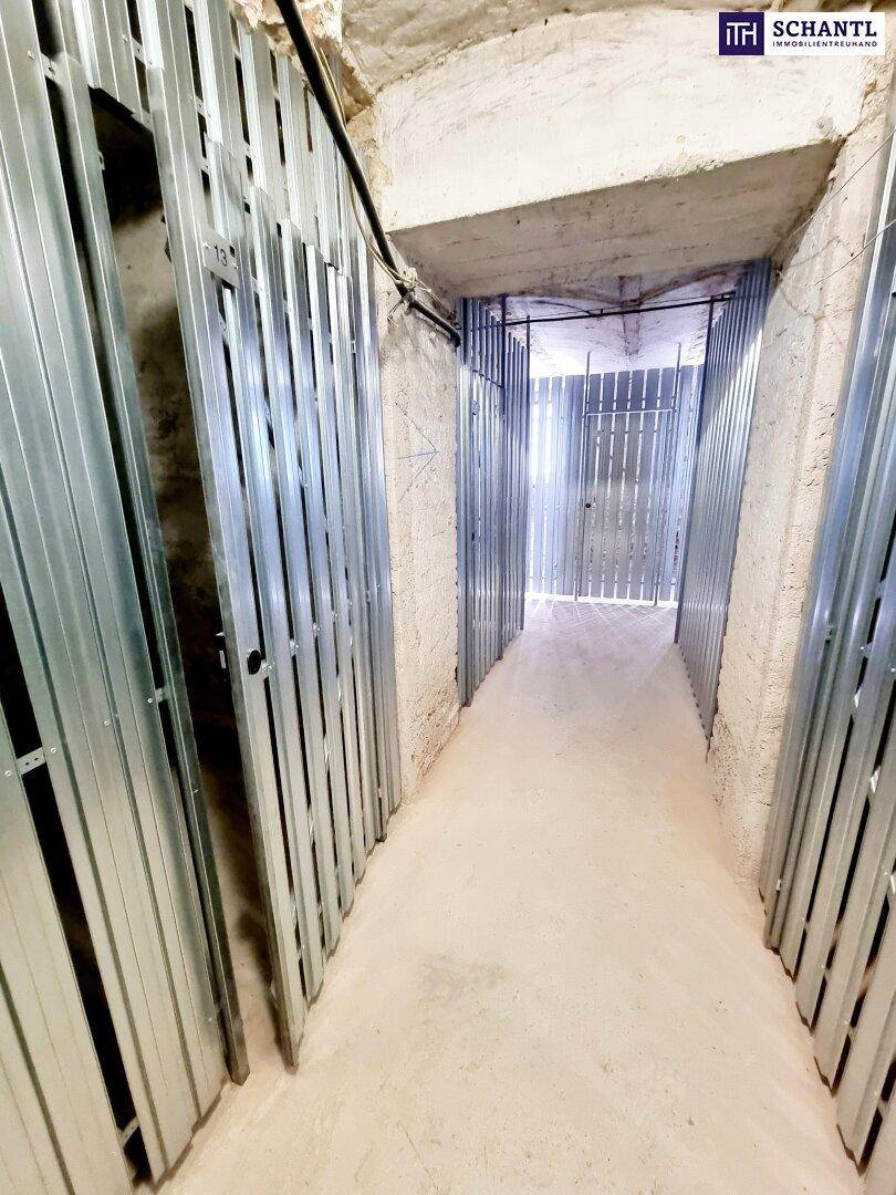 Heller Kellerflur mit Reihen von Metallabteilen, ideal für zusätzlichen Stauraum.