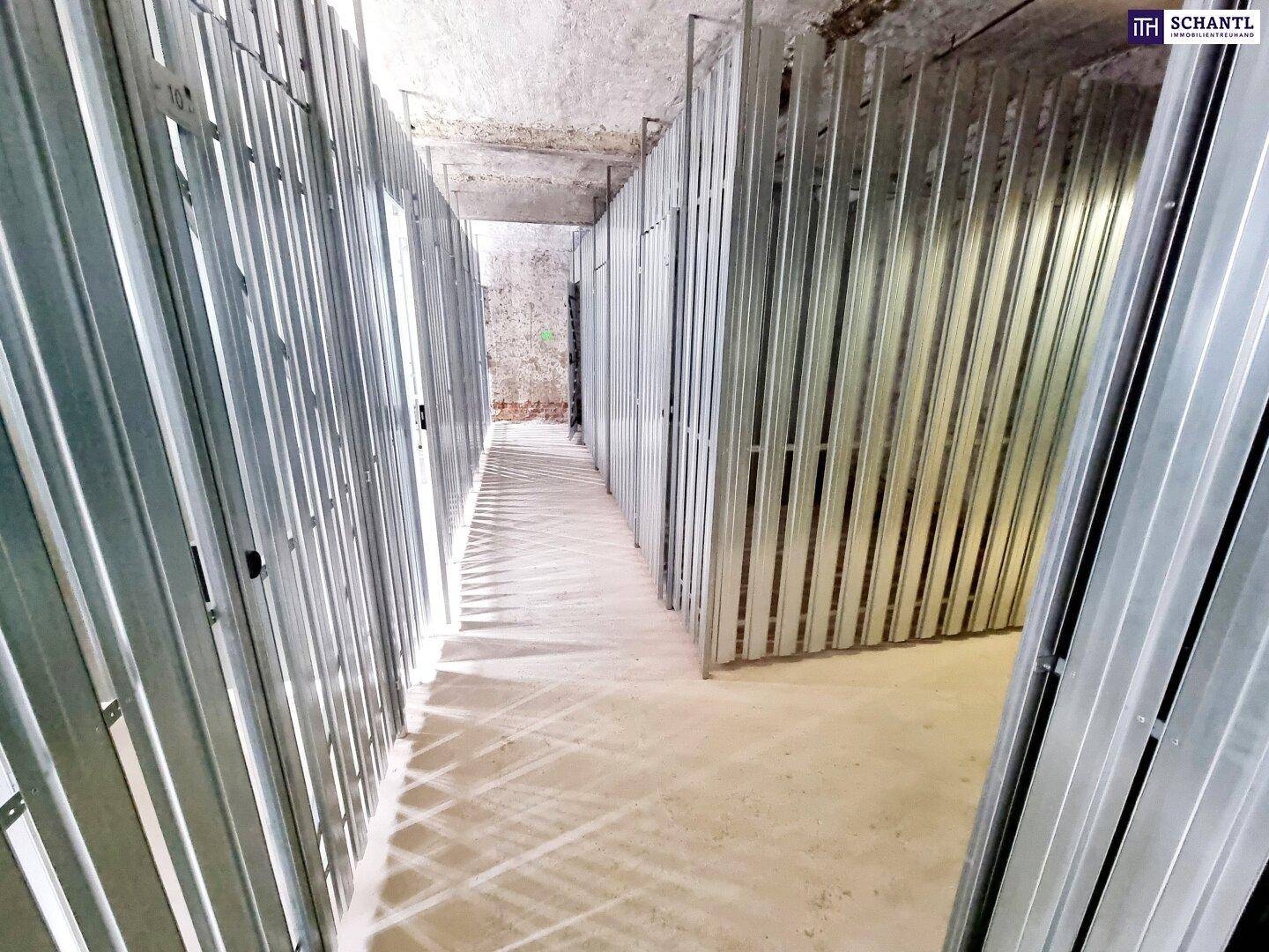 Kellergang mit modernen Metallabtrennungen, die neue Abstellräume definieren.