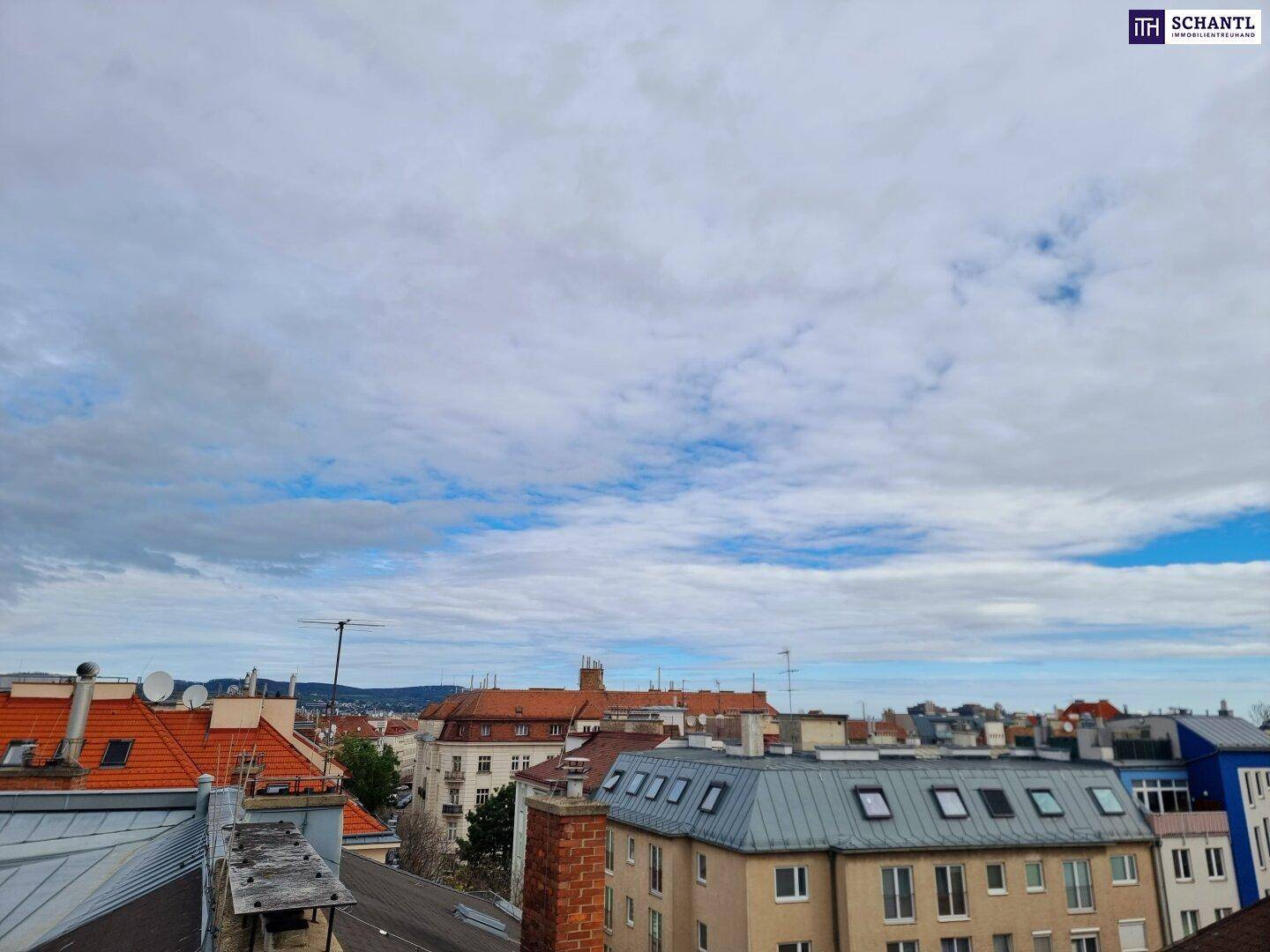 Weitläufiger Blick über die Dächer der Stadt unter einem bewölkten Himmel.