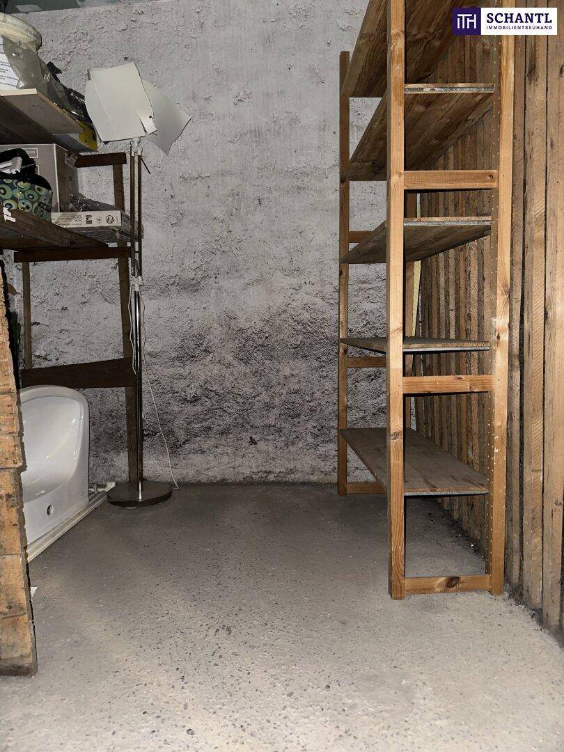 Kellerabteil mit Holzregalen und rauen Wänden für zusätzlichen Stauraum.