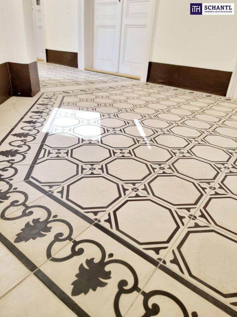 Nahaufnahme des historischen Fliesenbodens mit geometrischem Muster im Eingangsbereich.