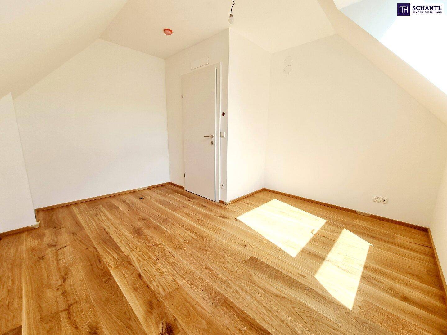 Leeres Zimmer im Dachgeschoss mit Holzboden und weißen Wänden, bereit zur individuellen Gestaltung und Einrichtung.