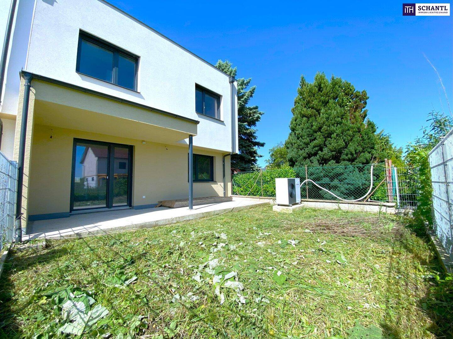 Hinterhof eines Reihenhauses mit Beton-Terrasse und unfertigem Gartenbereich.