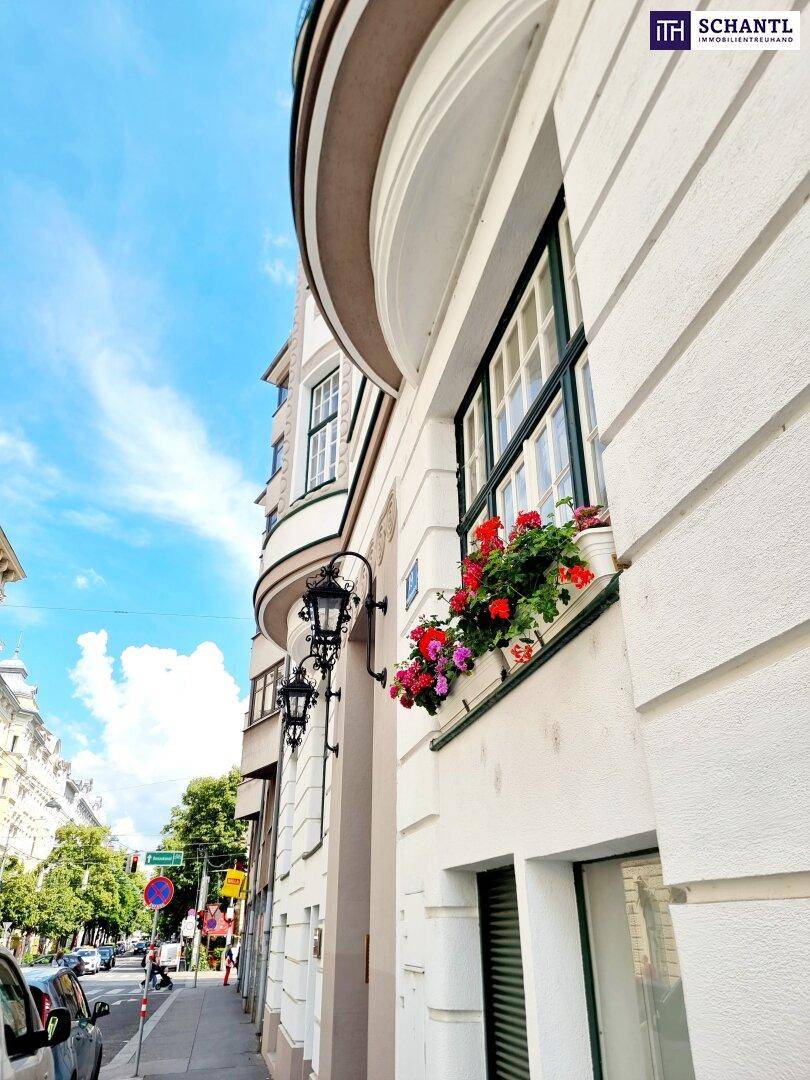 Historische Fassade mit Erkerfenstern, Blumenkästen und traditionellen Straßenlaternen.