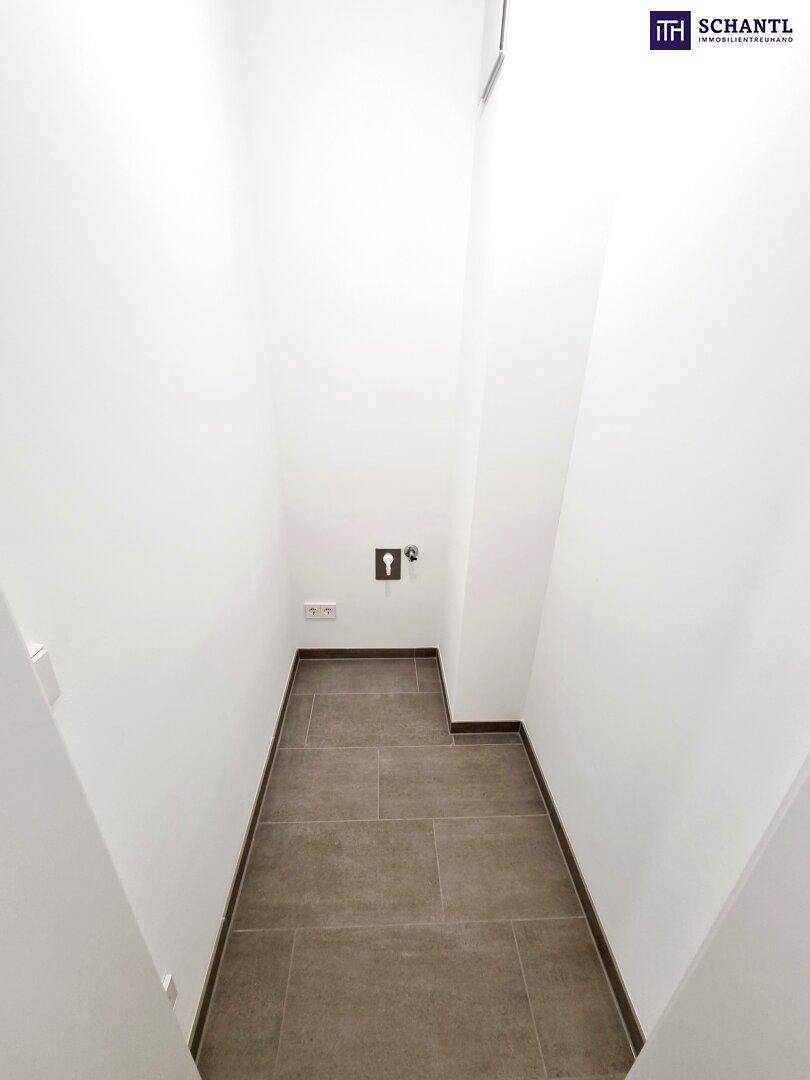 Kleiner Abstellraum mit Fliesenboden und Anschlüssen für Waschmaschine oder Technik.