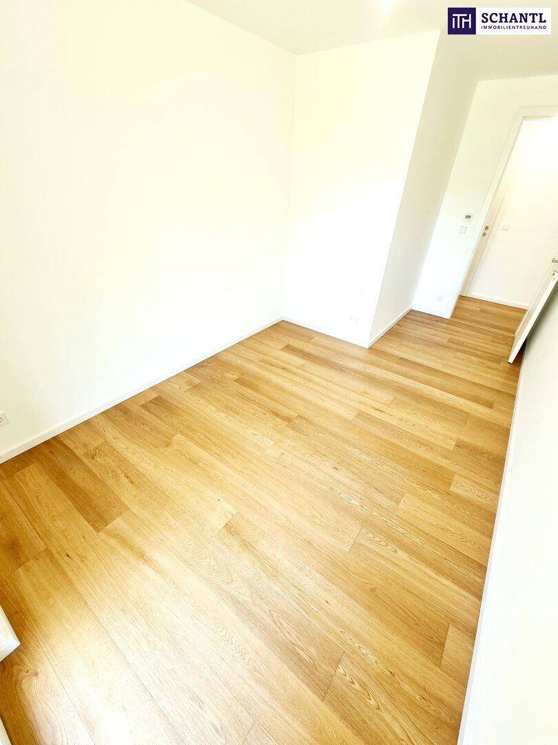 Ruhiges Zimmer mit hellem Holzboden und weißen Wänden, ideal als Schlaf- oder Arbeitszimmer.