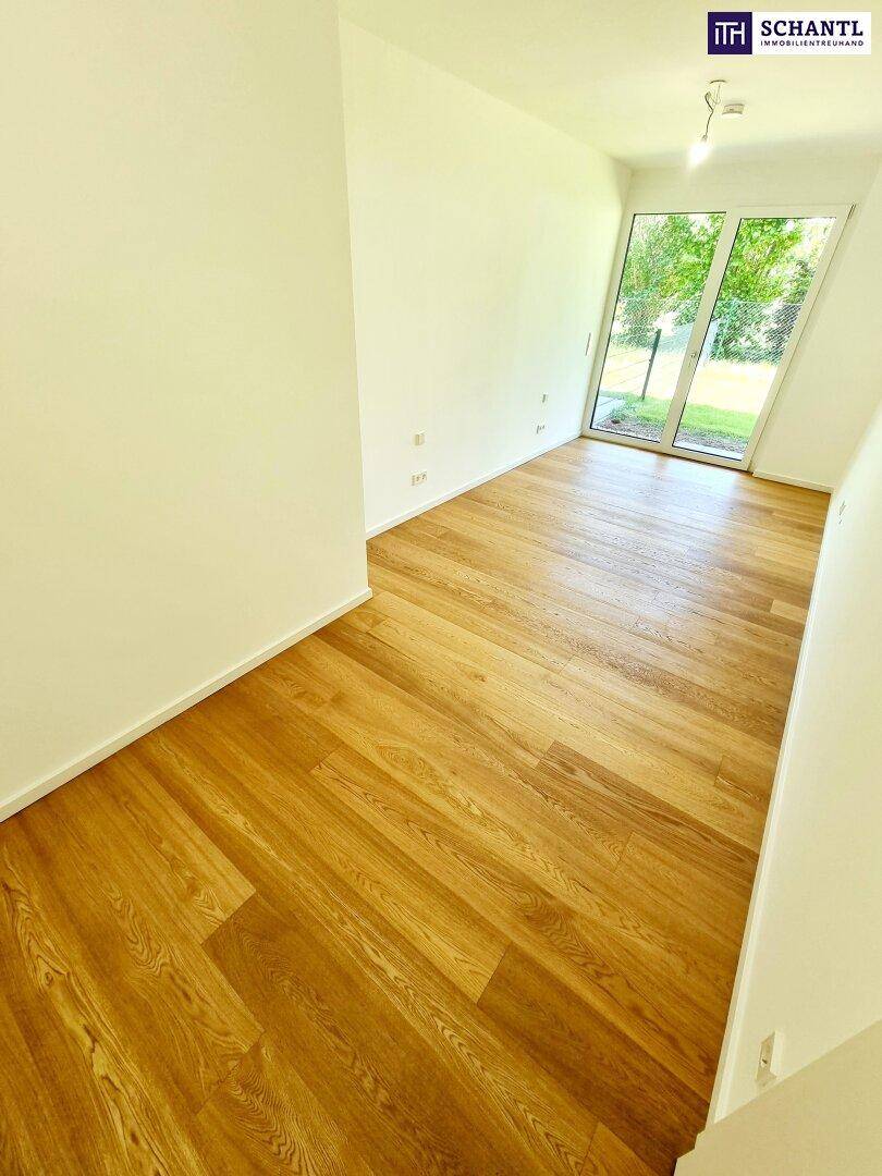 Helles Zimmer mit Holzboden und großen Fenstern, die einen schönen Blick ins Grüne ermöglichen.