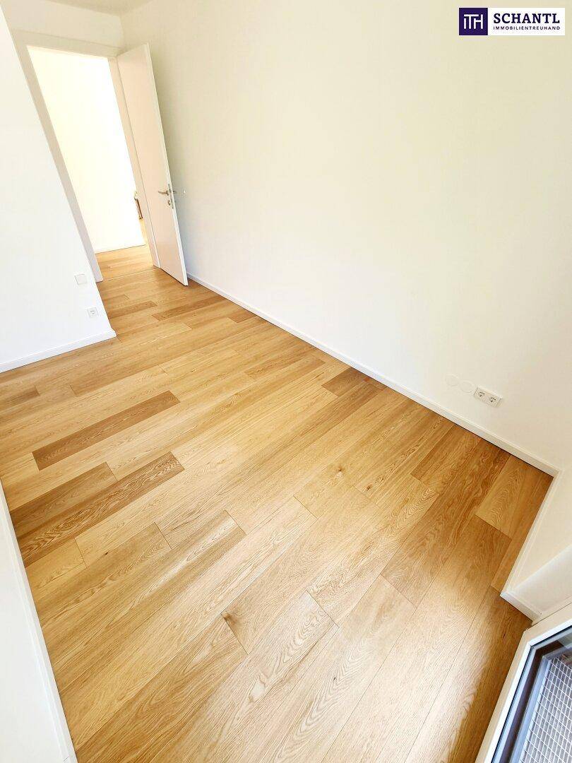 Leeres Zimmer mit hellem Holzfußboden und weißen Wänden, bereit zur individuellen Gestaltung.