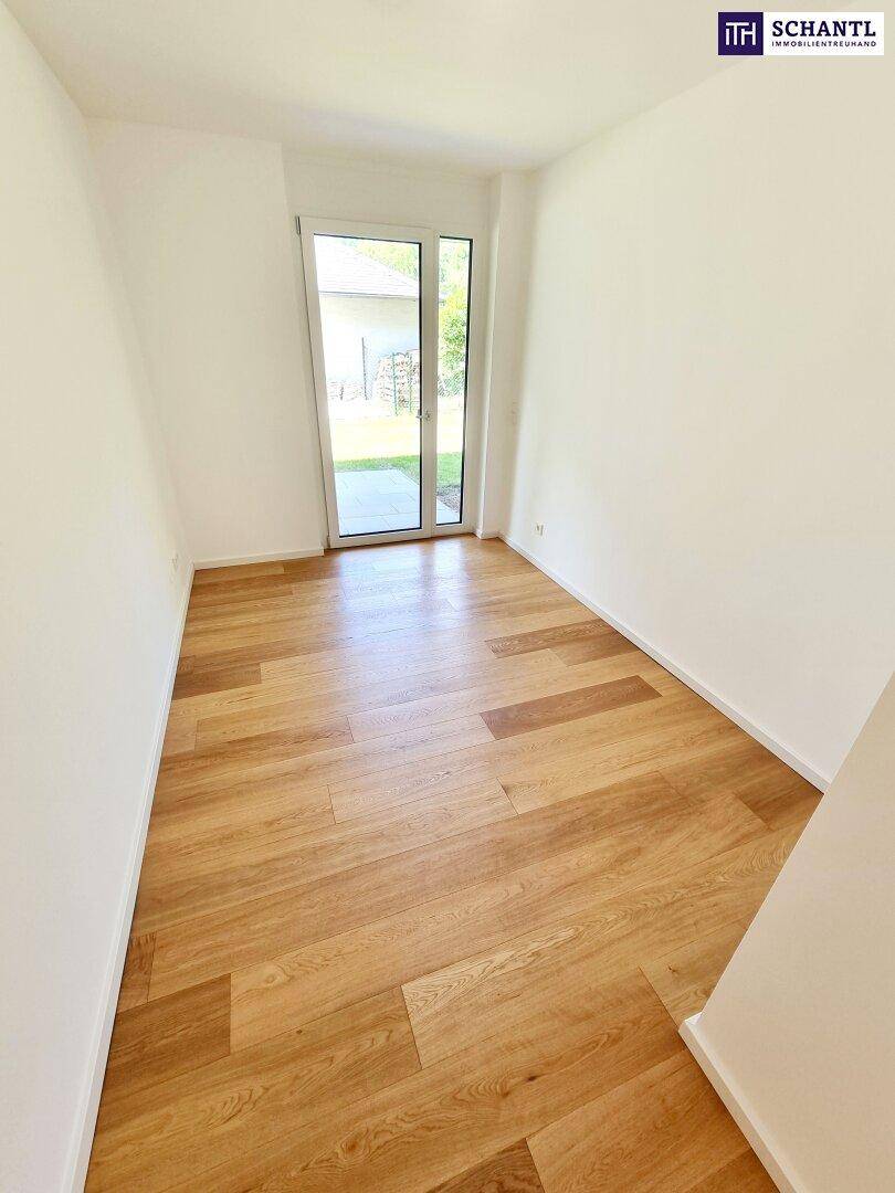 Helles Zimmer mit Zugang zur Terrasse oder zum Garten durch eine große Glastür.