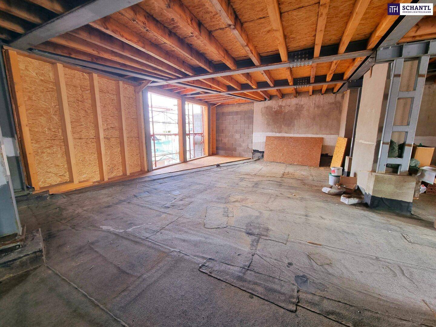 Rohbau eines großen Raumes mit sichtbarer Holzkonstruktion und viel Tageslicht, ideal für individuelle Gestaltung.