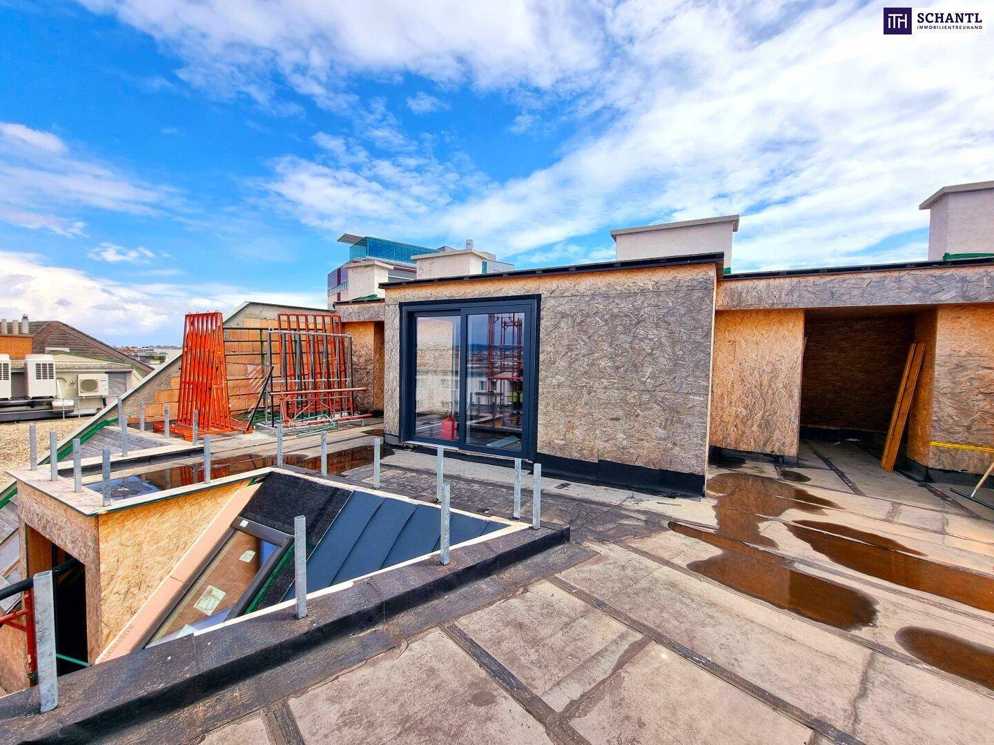 Dachterrasse im Bau mit großen Fenstern und Blick auf die Stadt, bereit für die Fertigstellung.