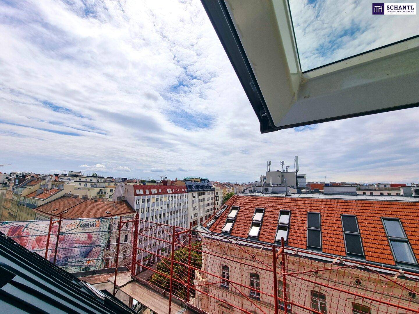 Panoramablick über die Dächer der Stadt aus einem Dachfenster.