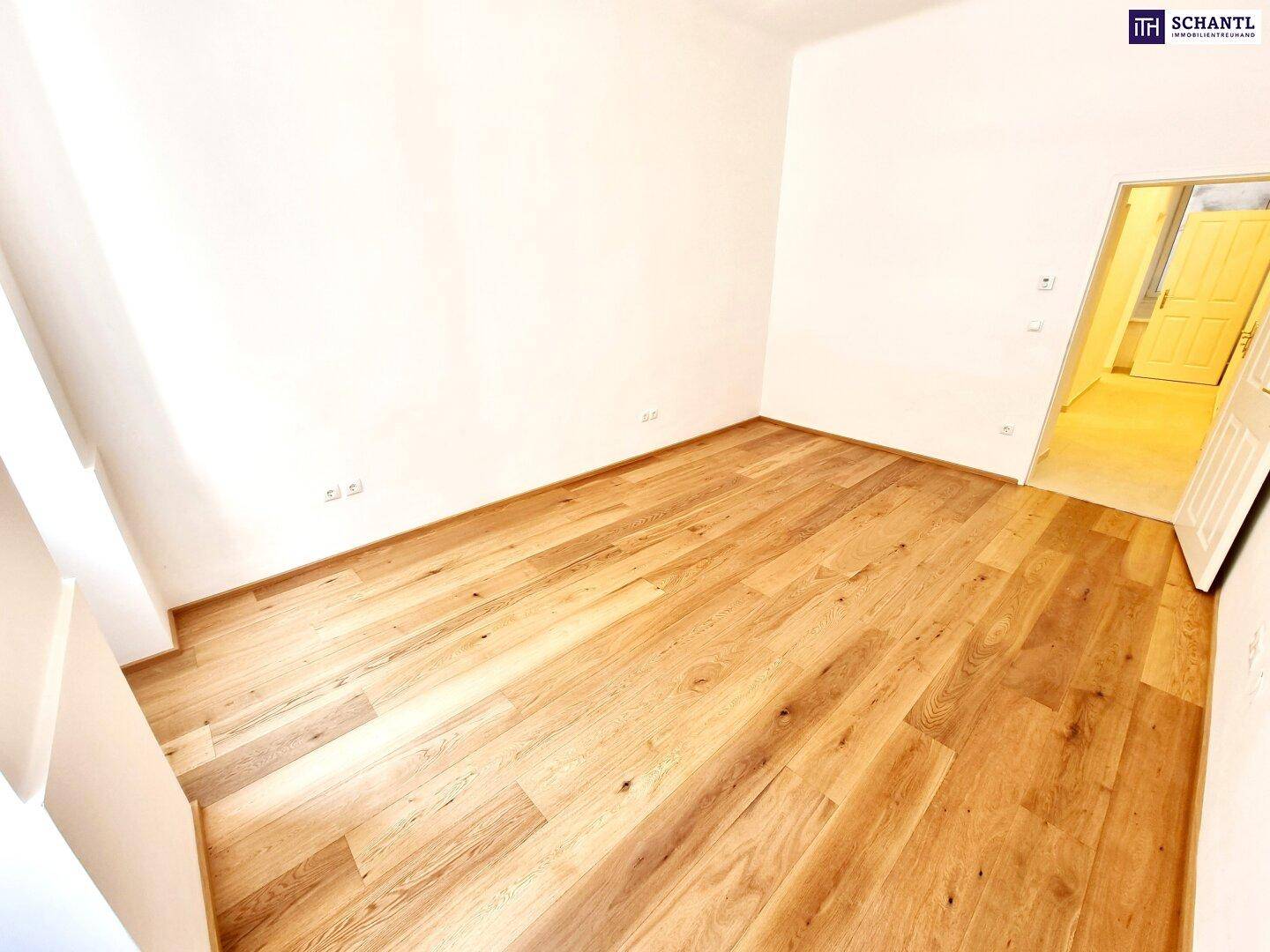 Heller Raum mit neuem Holzparkett und weißen Wänden, ideal für Schlaf- oder Wohnbereich.