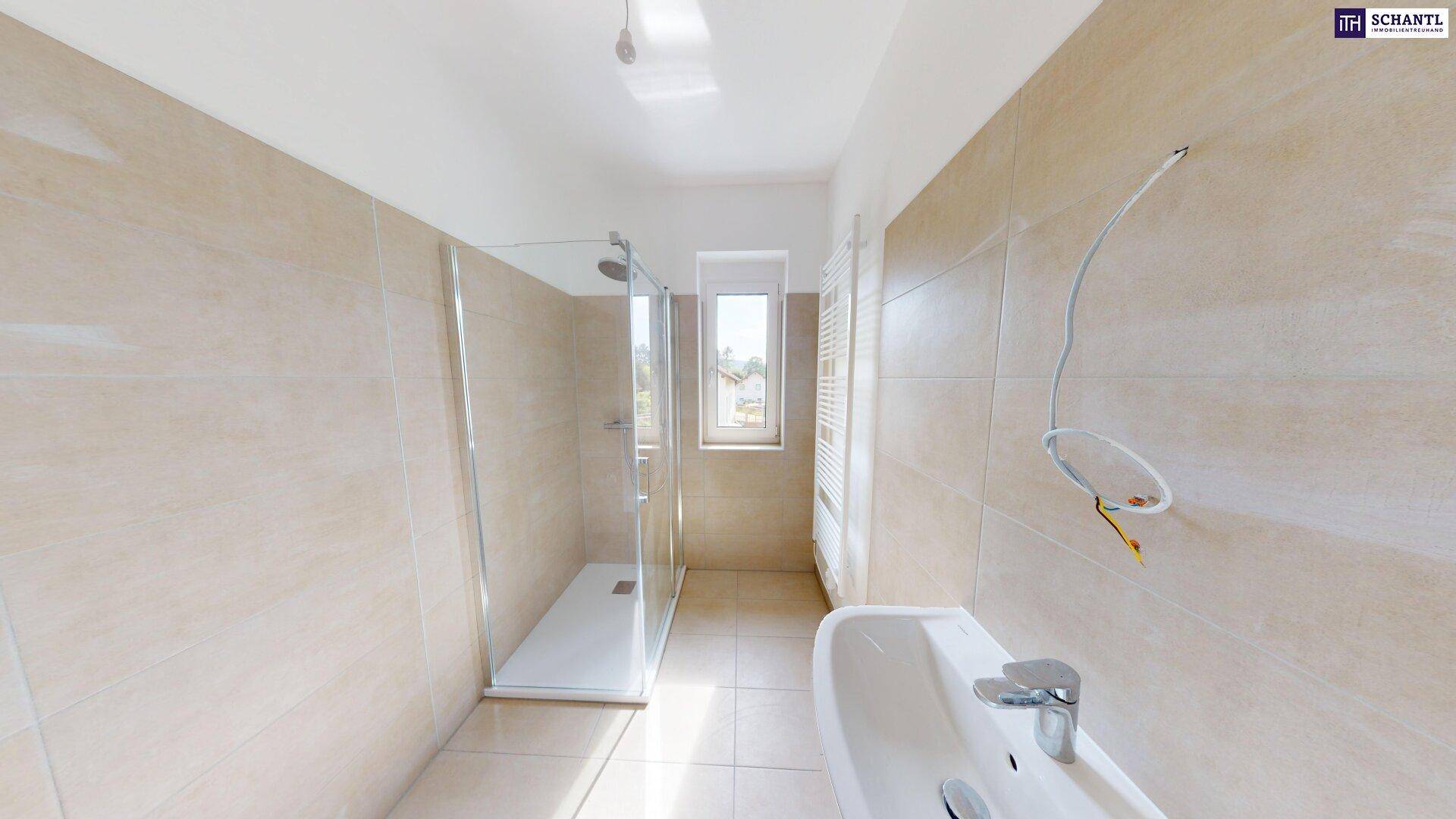 Modernes Badezimmer mit begehbarer Dusche, Fenster und beheiztem Handtuchhalter in hellen Fliesen.