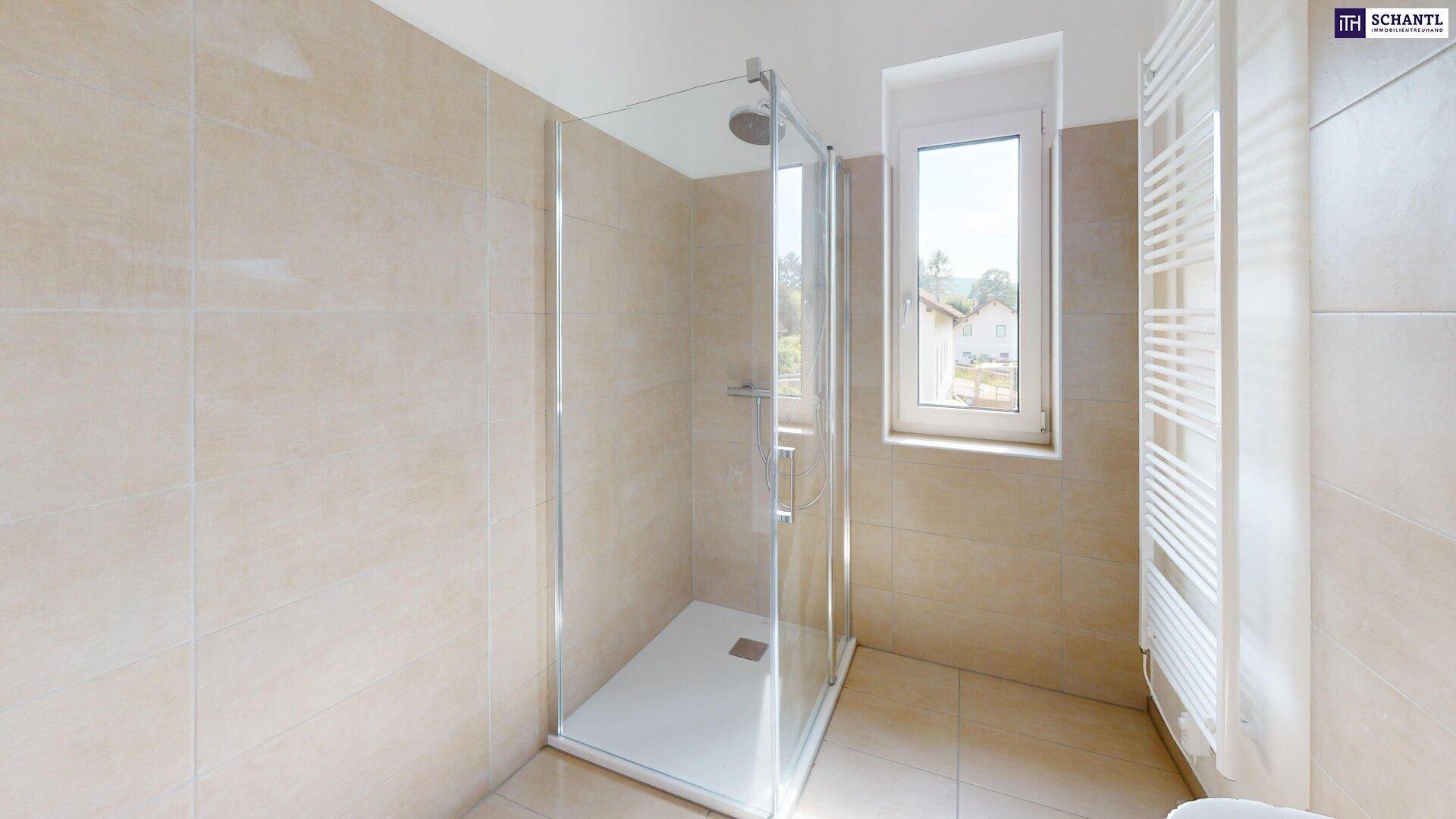 Modernes Badezimmer mit großer begehbarer Dusche, Fenster und Handtuchheizkörper in hellen Fliesen.