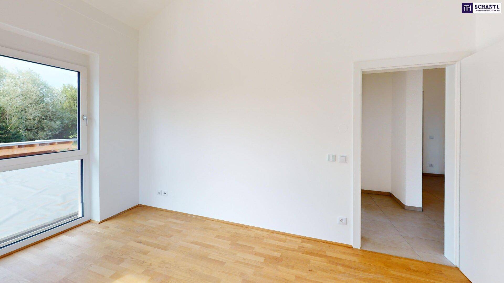 Helles Zimmer mit Parkettboden und Türöffnung zu einem weiteren Raum, ideal als Schlafzimmer.