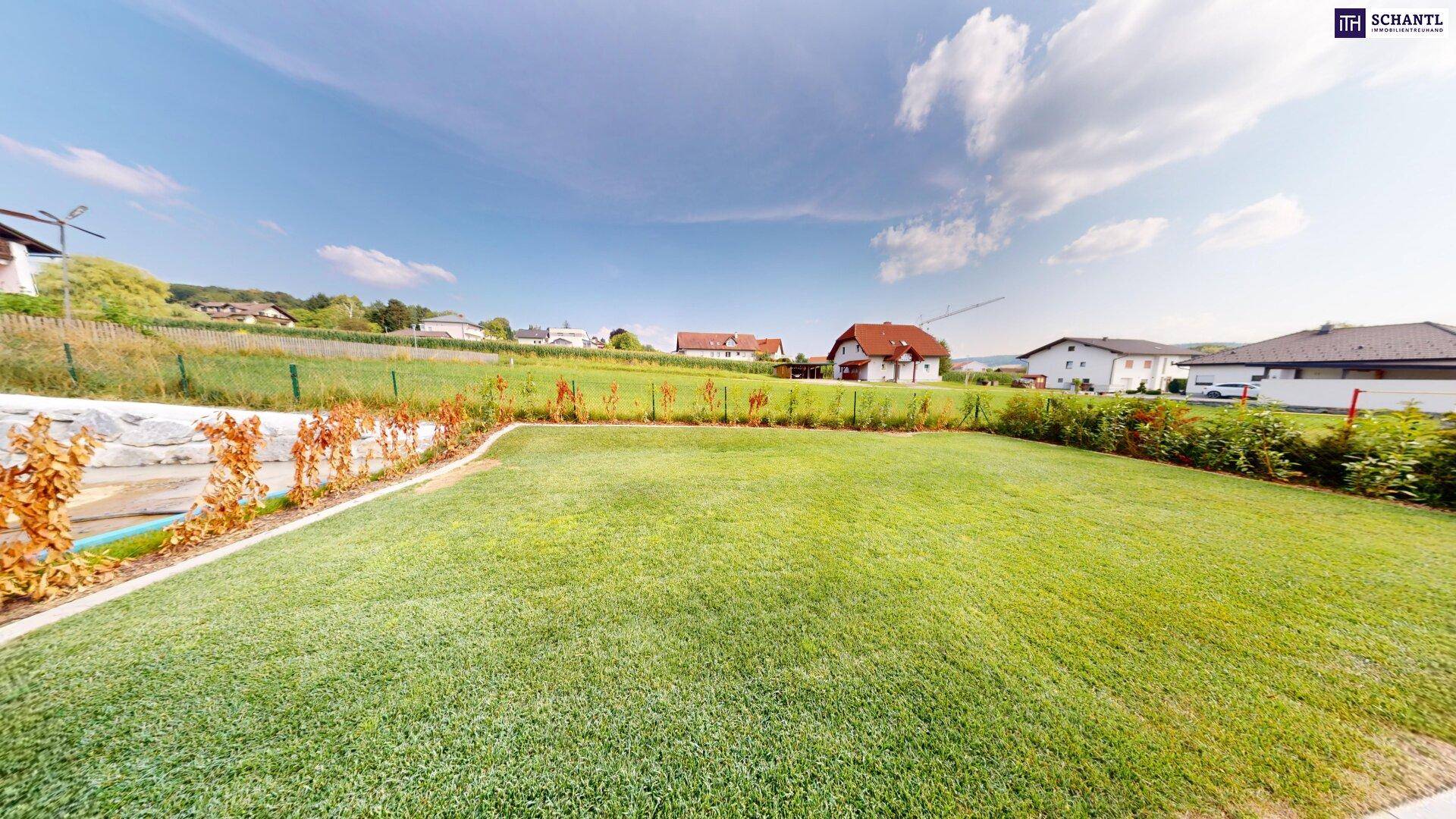 Gepflegter Garten mit Rasenfläche und Blick auf die umliegende Landschaft.