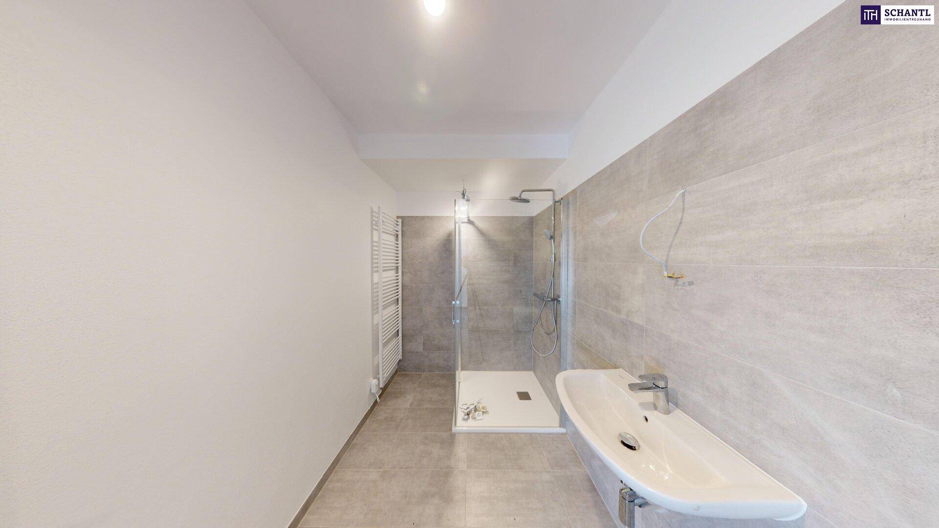 Modernes Badezimmer mit großer Dusche, Waschbecken und hellen Fliesen.