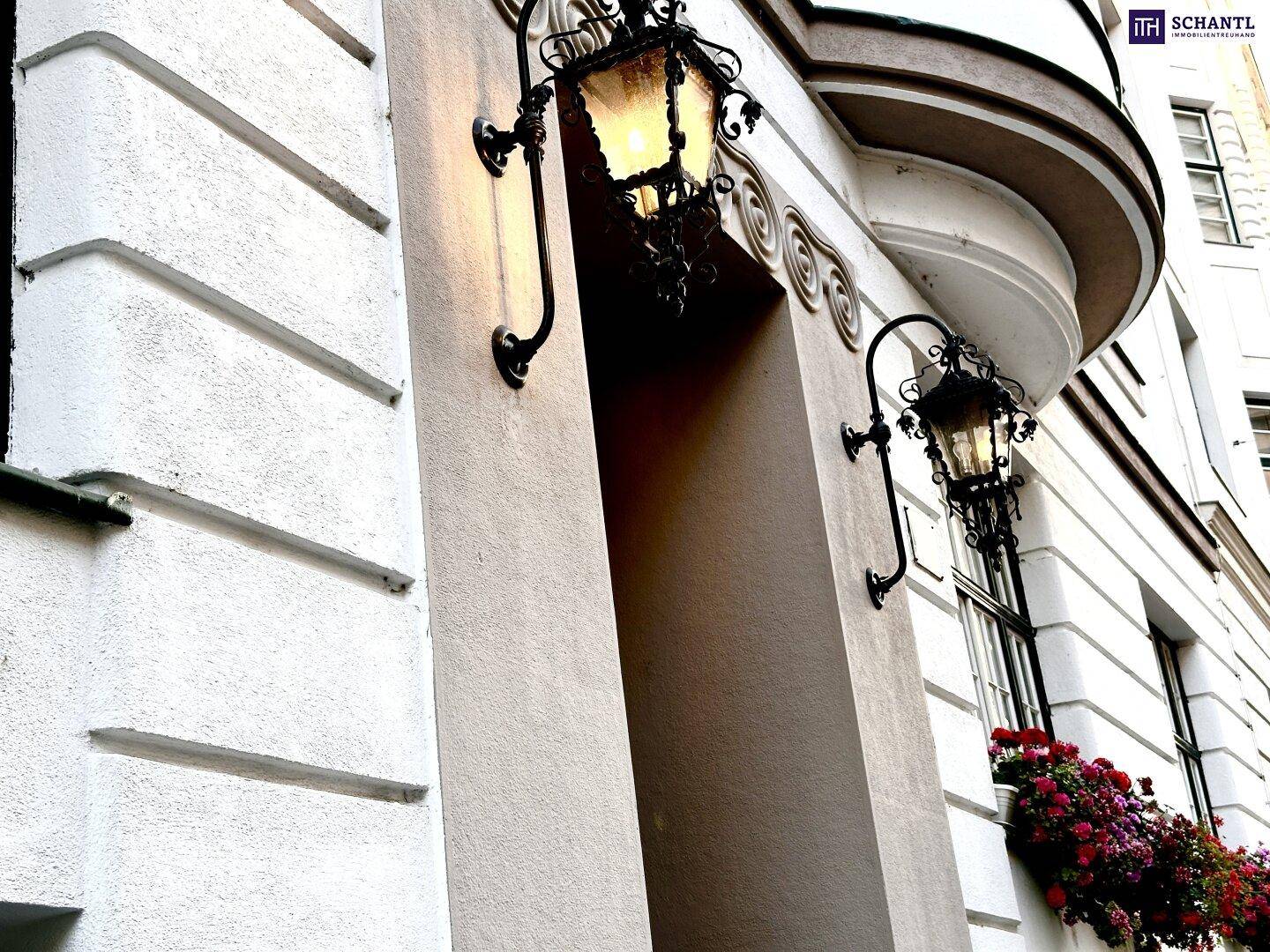Detailansicht der historischen Fassade mit dekorativen Laternen und Blumenkästen.