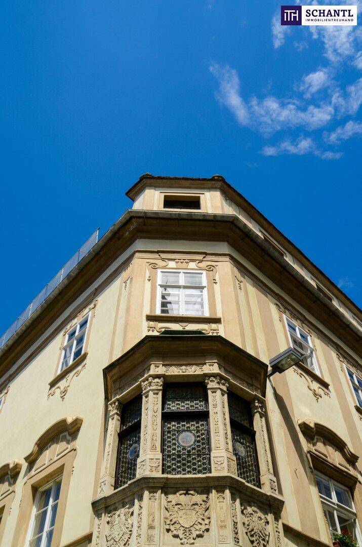 Eckansicht eines historischen Gebäudes mit einem markanten Erker unter blauem Himmel.