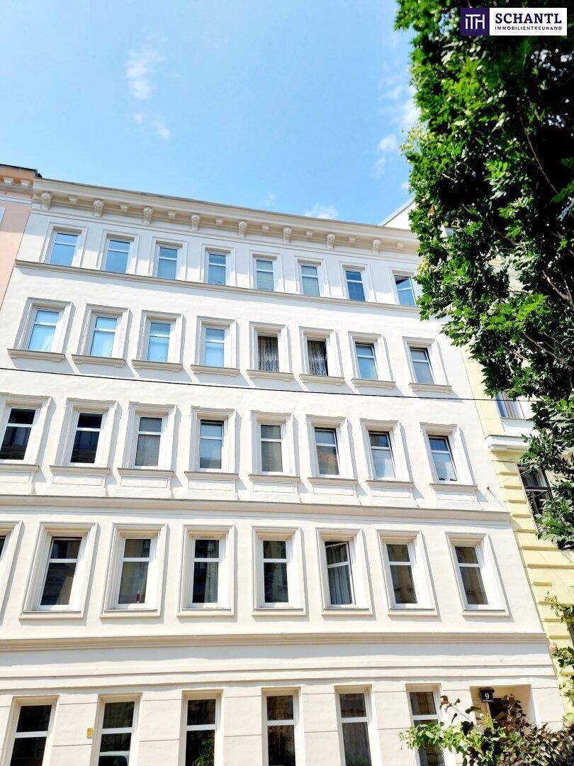 Historische Gebäudefassade mit vielen Fenstern und klassischer Architektur unter blauem Himmel.